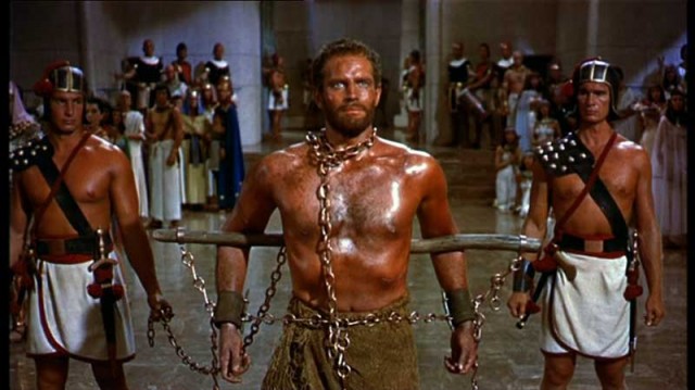 صحنه ای از فیلم ده فرمان، که موسی را به عنوان برده نشان می دهد که او را به حضور فرعون میبرند.